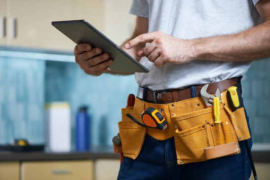 Sc&egrave;ne d'atelier plomberie avec raccords flexibles et outils sur plans techniques